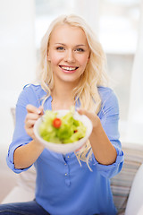 Image showing smiling young woman with green salad at home