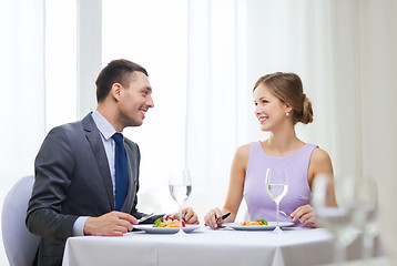 Image showing smiling couple eating main course at restaurant