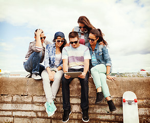 Image showing group of teenagers looking at tablet pc