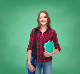 Image showing smiling female student with bag and notebooks