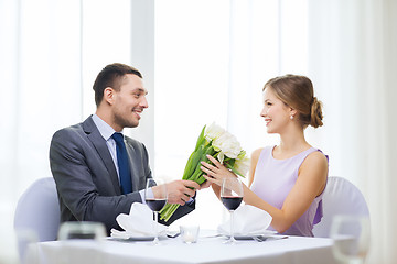 Image showing smiling man giving flower bouquet at restaurant