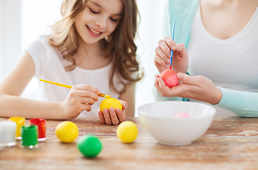 Image showing close up of little girl and mother coloring eggs