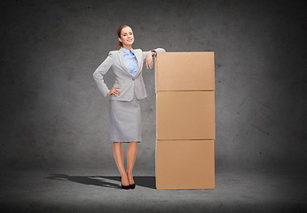 Image showing smiling businesswoman with cardboard boxes