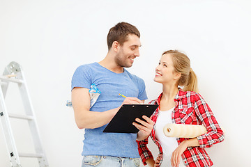 Image showing smiling couple with clipboard and wallpaper roll