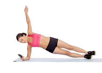 Image showing asian sporty woman with smartphone doing exercise