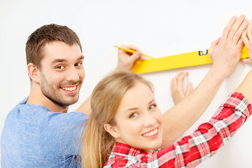 Image showing couple building using spirit level to measure