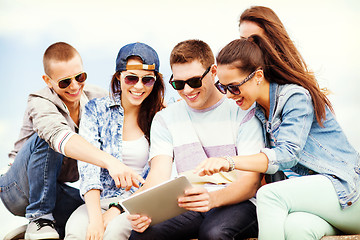 Image showing group of teenagers looking at tablet pc