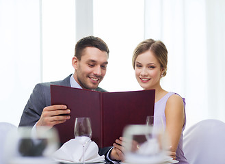 Image showing smiling couple with menu at restaurant