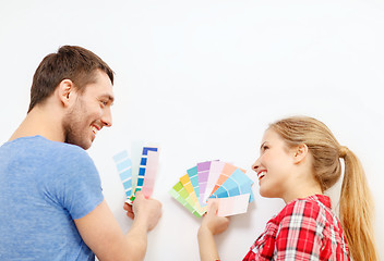 Image showing smiling couple looking at color samples at home