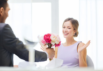 Image showing amazed woman recieving bouquet of flowers