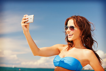 Image showing happy woman with phone on the beach