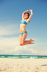 Image showing happy jumping woman on the beach