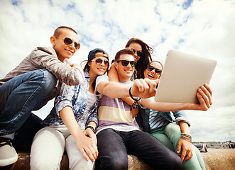 Image showing group of teenagers looking at tablet pc