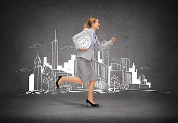 Image showing smiling young businesswoman with clock running