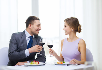Image showing couple with main course and red wine at restaurant