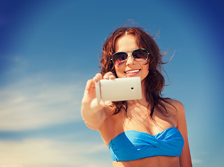 Image showing happy woman with phone on the beach