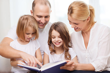 Image showing smiling family and two little girls with book
