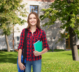 Image showing smiling female student with bag and notebooks