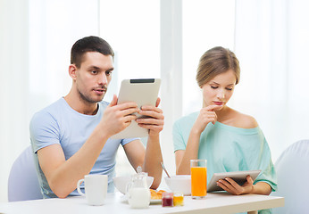 Image showing concentrated couple with tablet pc reading news