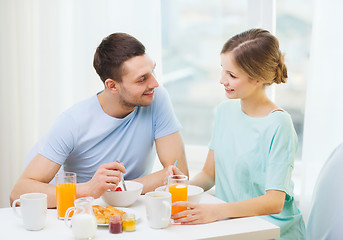 Image showing smiling couple having breakfast at home