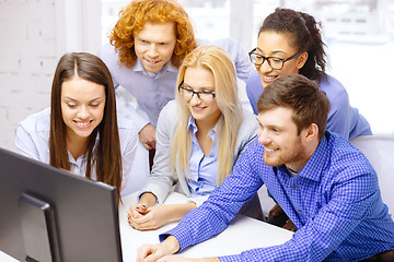 Image showing smiling business team looking at computer monitor