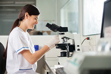 Image showing Happy Female Scientist Using Microscope In Lab