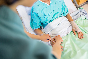 Image showing Nurse Attaching IV Drip On Male Patient's Hand In Hospital