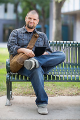 Image showing Confident Male Student Sitting On Bench At Campus