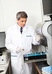 Image showing Scientist Loading Analyzer With Samples