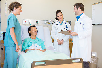 Image showing Doctors Discussing Notes While Patient And Nurse Looking At Them