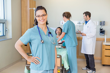 Image showing Nurse With Hand On Hip Against Patient And Medical Team