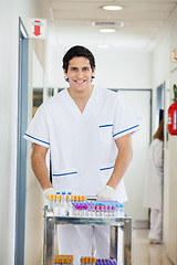 Image showing Technician Pushing Medical Cart In Hospital Hallway