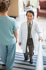 Image showing Doctor Climbing While Nurse Walking Down Hospital Stairs