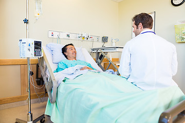 Image showing Smiling Patient Looking At Doctor While Lying On Hospital Bed