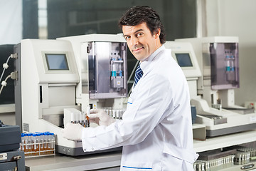 Image showing Scientist Using Urine Analyzer To Test Samples