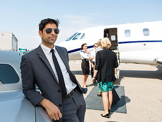 Image showing Businessman Leaning On Car At Airport Terminal