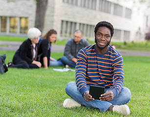 Image showing Portrait Of Student Sitting On Grass At Campus Park