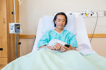 Image showing Patient Text Messaging Through Cell Phone On Hospital Bed