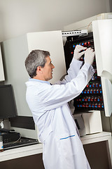 Image showing Technician Placing Bottles Into Blood Culture Instrument