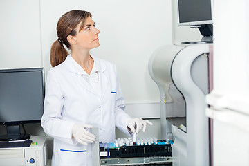 Image showing Scientist Loading Coagulation Analyzer With Test Samples