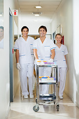 Image showing Technicians With Medical Cart Walking In Corridor