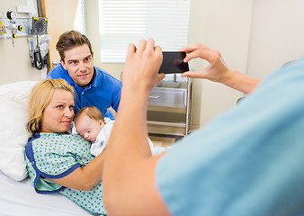 Image showing Nurse Photographing Couple With Newborn Baby Through Mobilephone