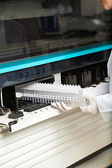 Image showing Technician Placing Samples In Analyzer