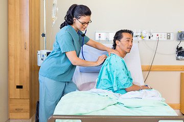 Image showing Nurse Examining Male Patient's Back With Stethoscope On Hospital