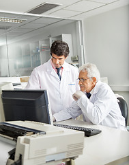 Image showing Technicians Discussing Over Computer