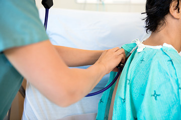 Image showing Female Nurse Examining Patient's Back With Stethoscope