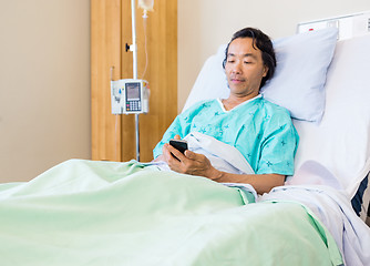 Image showing Patient Using Mobile Phone On Hospital Bed