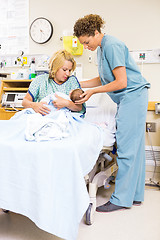 Image showing Nurse Assisting Woman In Holding Newborn Baby At Hospital