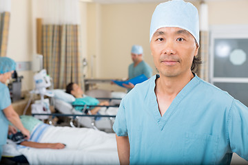 Image showing Male Nurse With Colleagues Examining Patient's In Ward