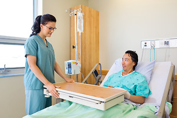 Image showing Nurse Placing Overbed Table For Male Patient